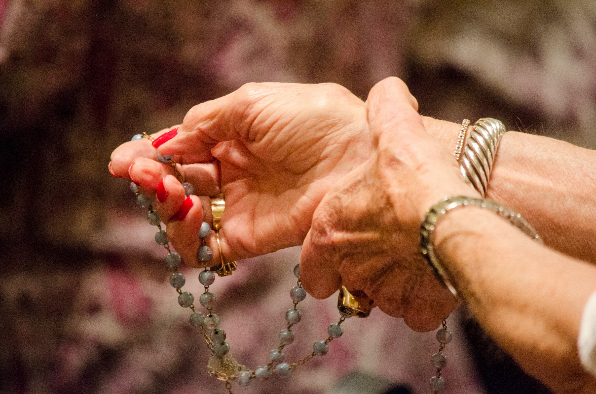 Close-up of a woman's hands holding rosary beads