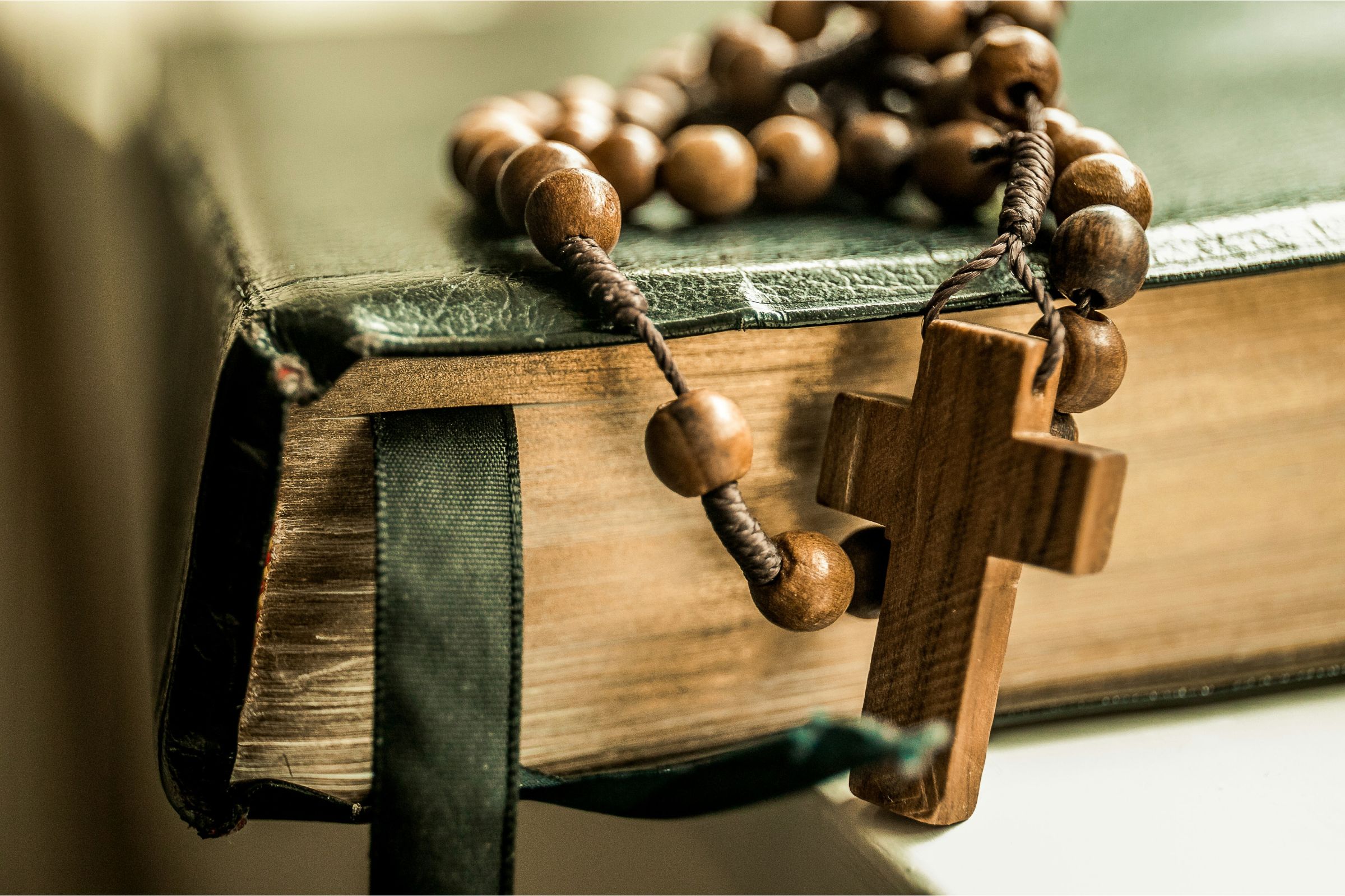 Close-up of a Bible with wooden rosary beads
